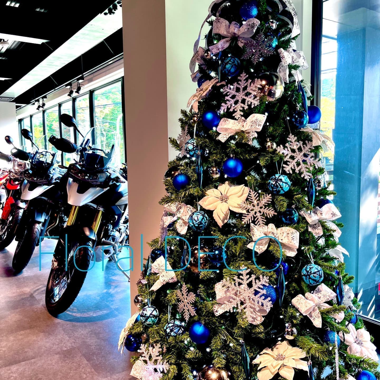 クリスマスツリーレンタルの利用例。店舗に設置された、オーナメントと電飾で華やかに飾られたクリスマスツリー